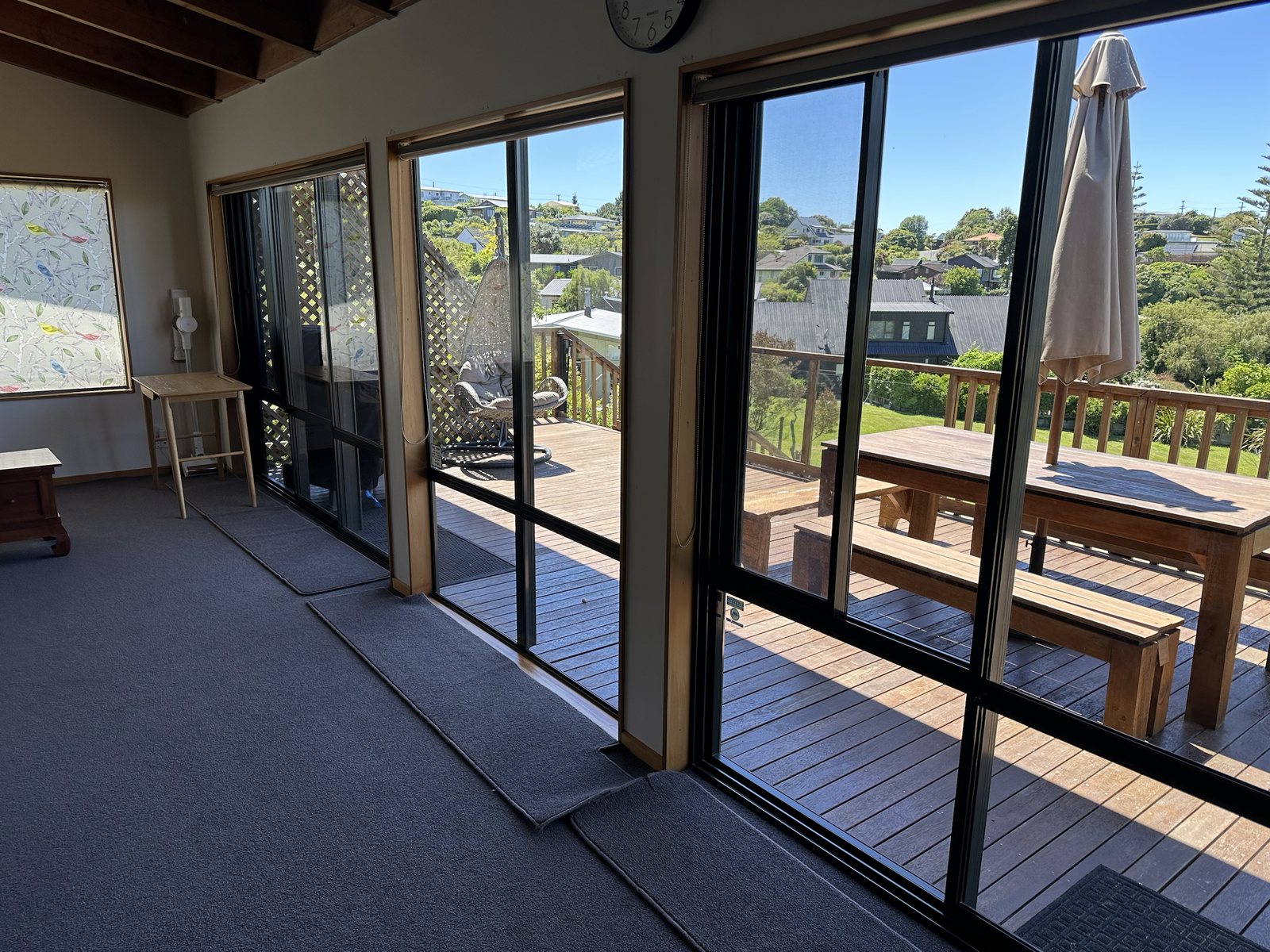 Deck dining table looking out to surrounding greenery and bay
