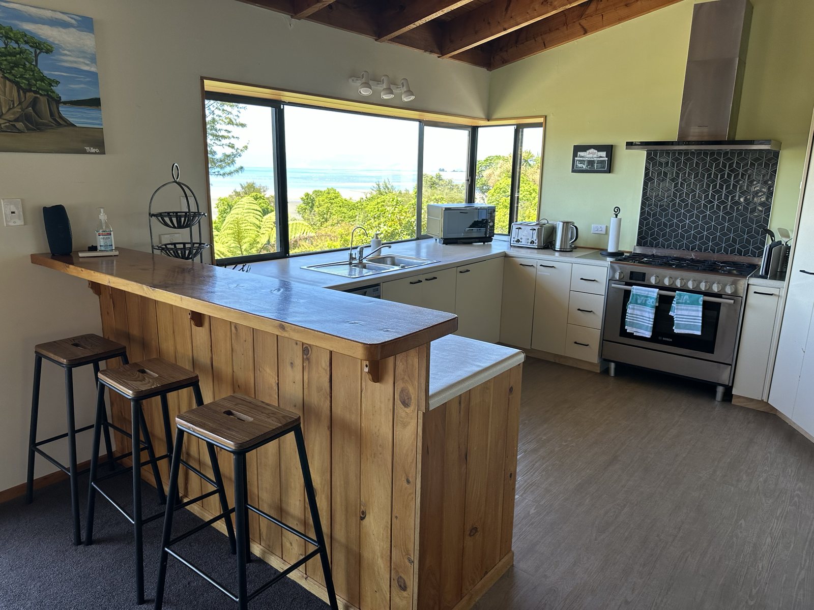 Kitchen with timber breakfast bar and view toward the bay