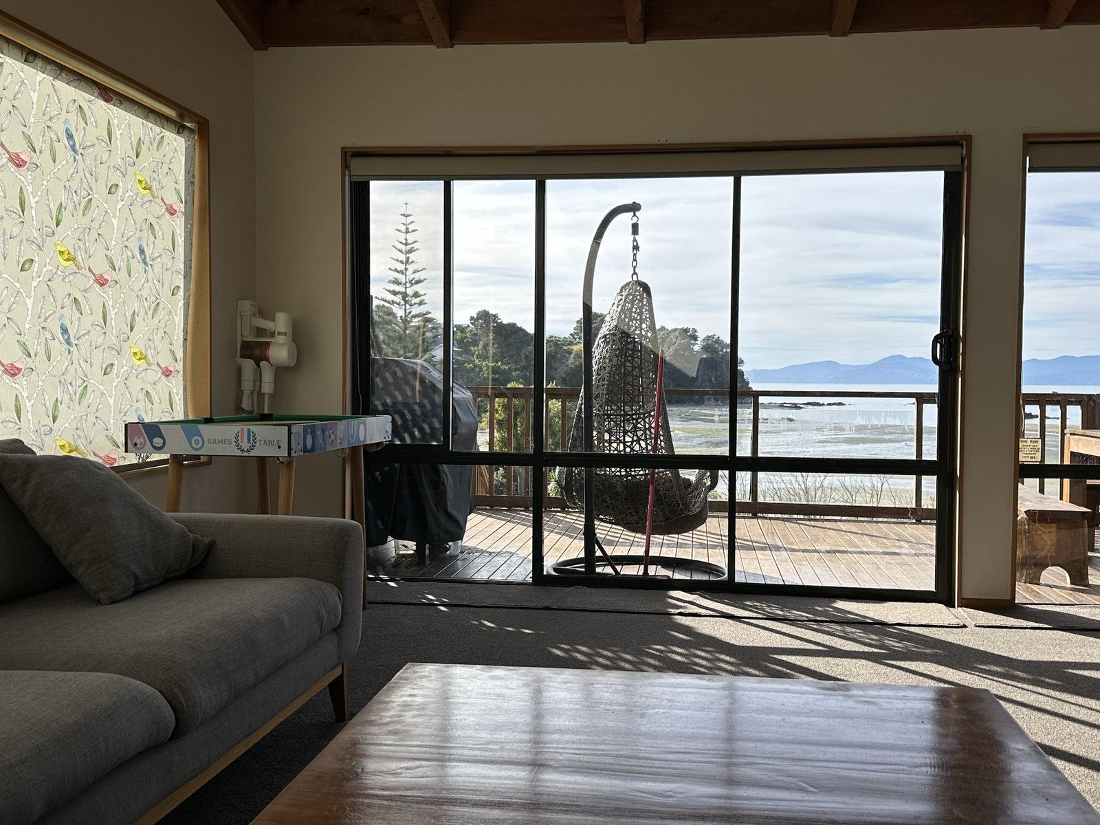 Living room with doors open to the deck and sea view